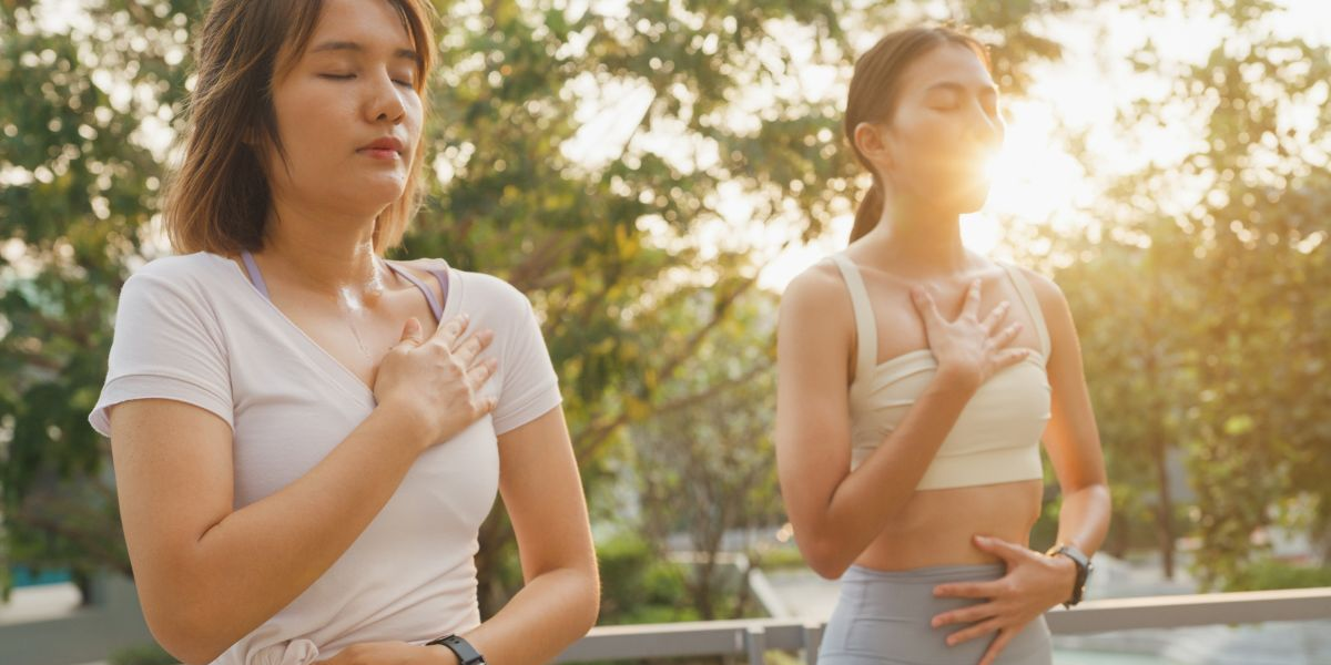 Person sitting calmly with eyes closed, practicing mindfulness and deep breathing to reduce stress and anxiety